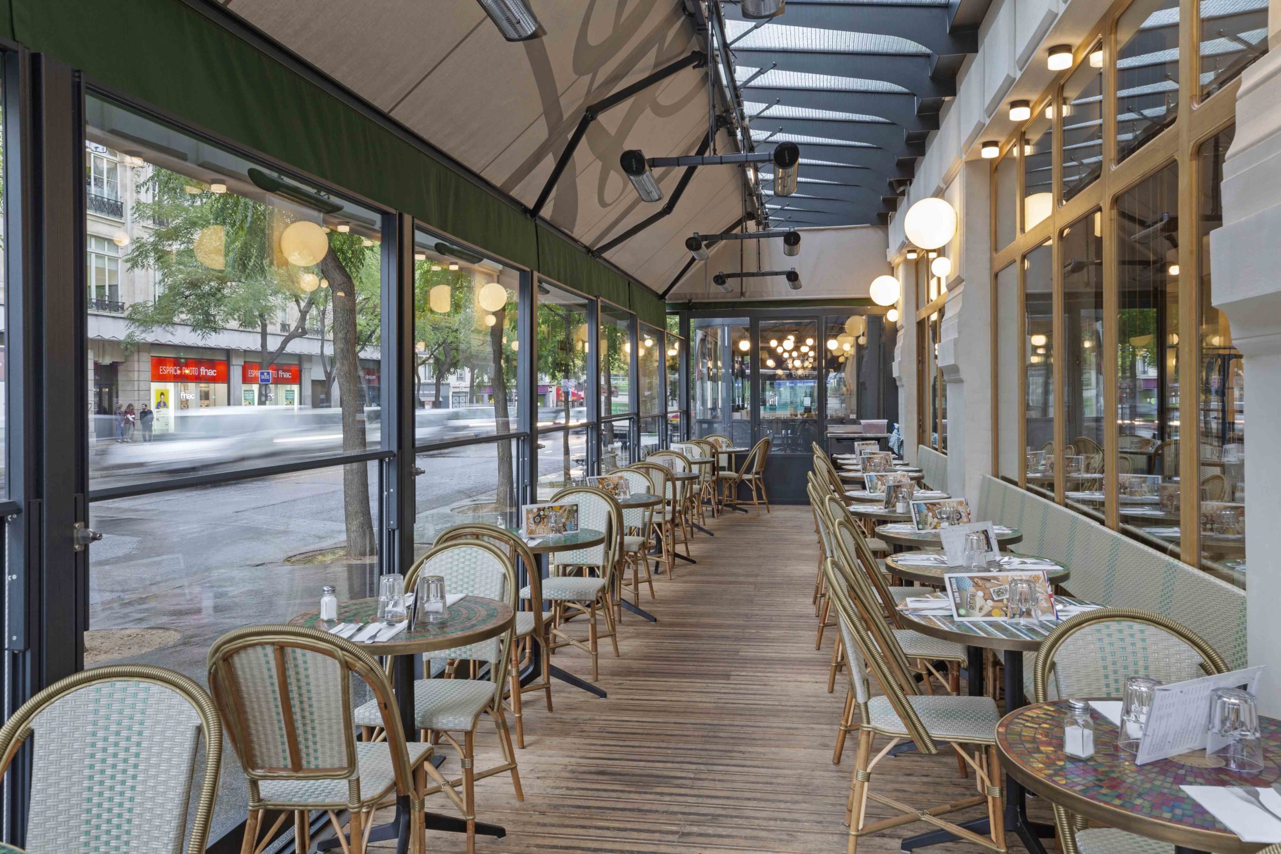 Restaurant avec terrasse ouverte comprenant paravents guillotines verticaux, plancher et store banne