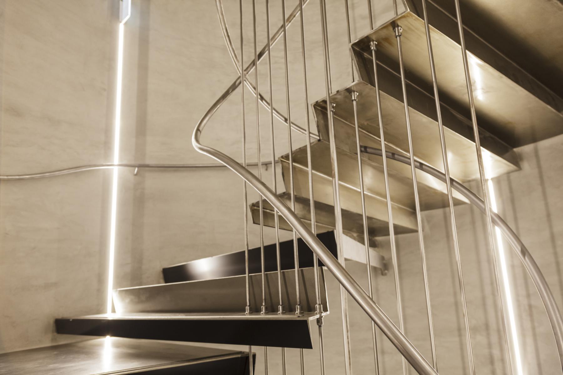 Escalier acier quart tournant avec main courante en tube acier et garde-corps "rideau" en tubes ronds verticaux