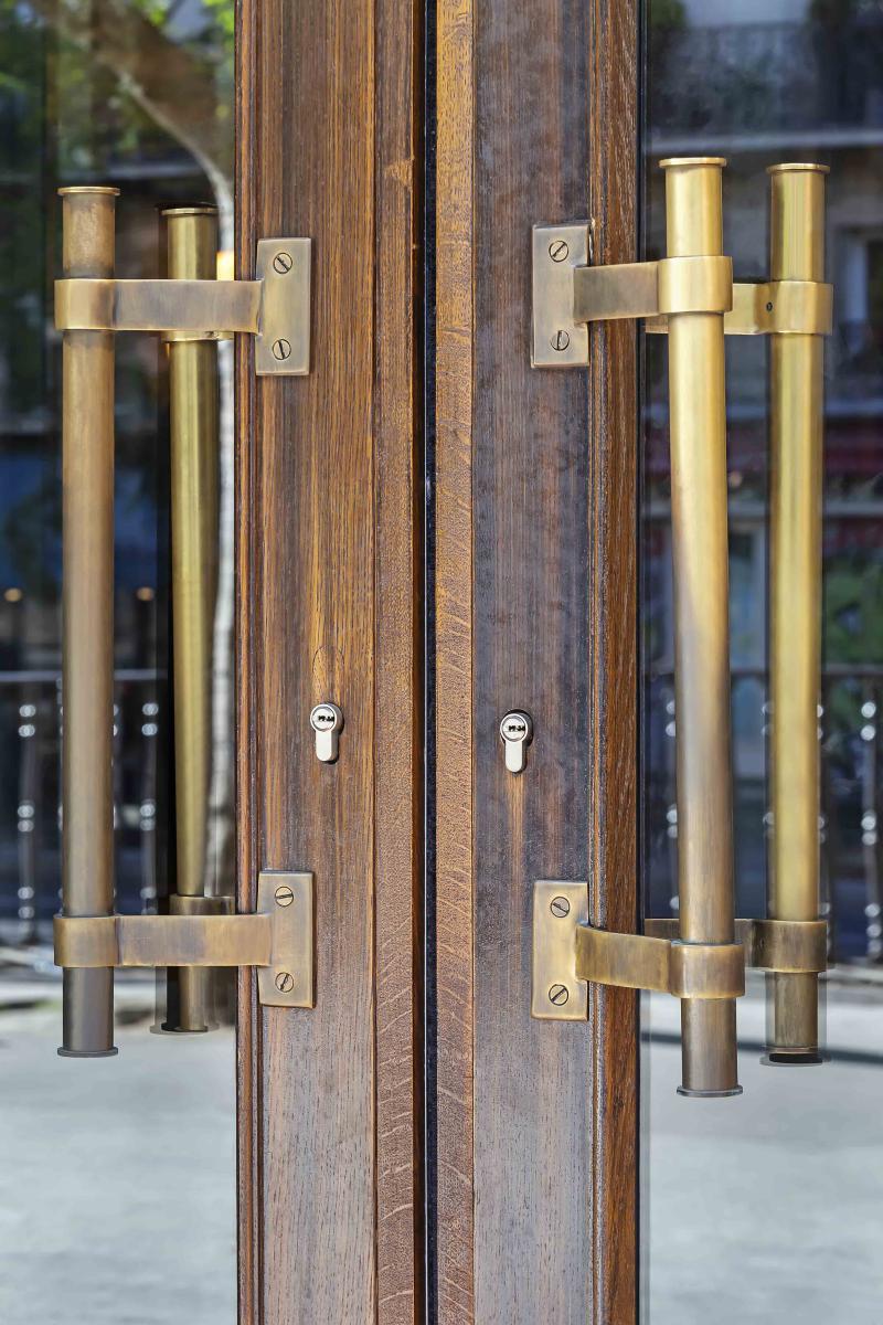Poignées bâton de maréchal bronze sur porte en bois à l'ancienne