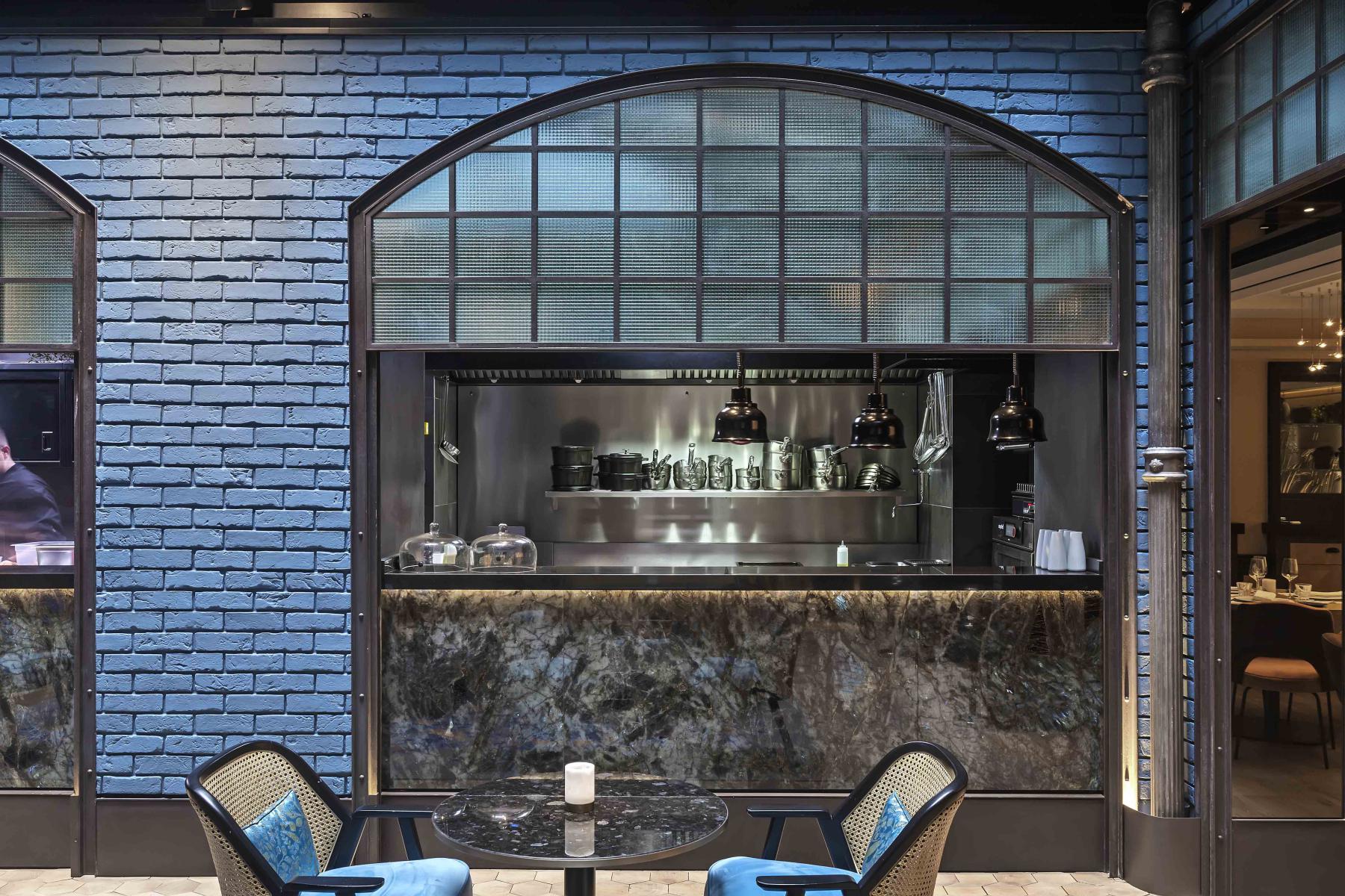 Cloison vitrée de séparation style industrielle entre une salle de restaurant et un cuisine
