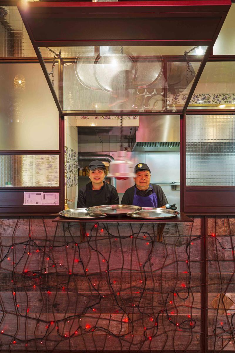 Parois vitrée séparative entre une cuisine et une salle de restaurant avec système d'ouverture