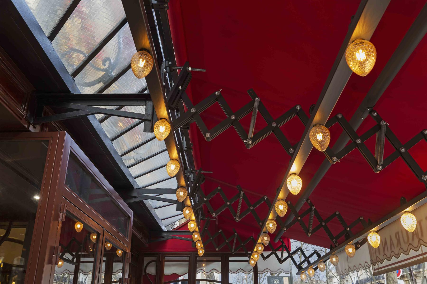 Barre de support d'ampoules à filaments sous un store d'un restaurant style Art Nouveau 1900
