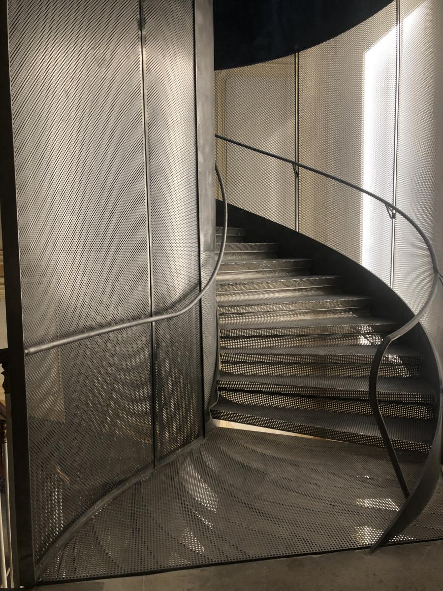 Main courante cintrée et débillardée en tube acier brut pour un escalier contemporain