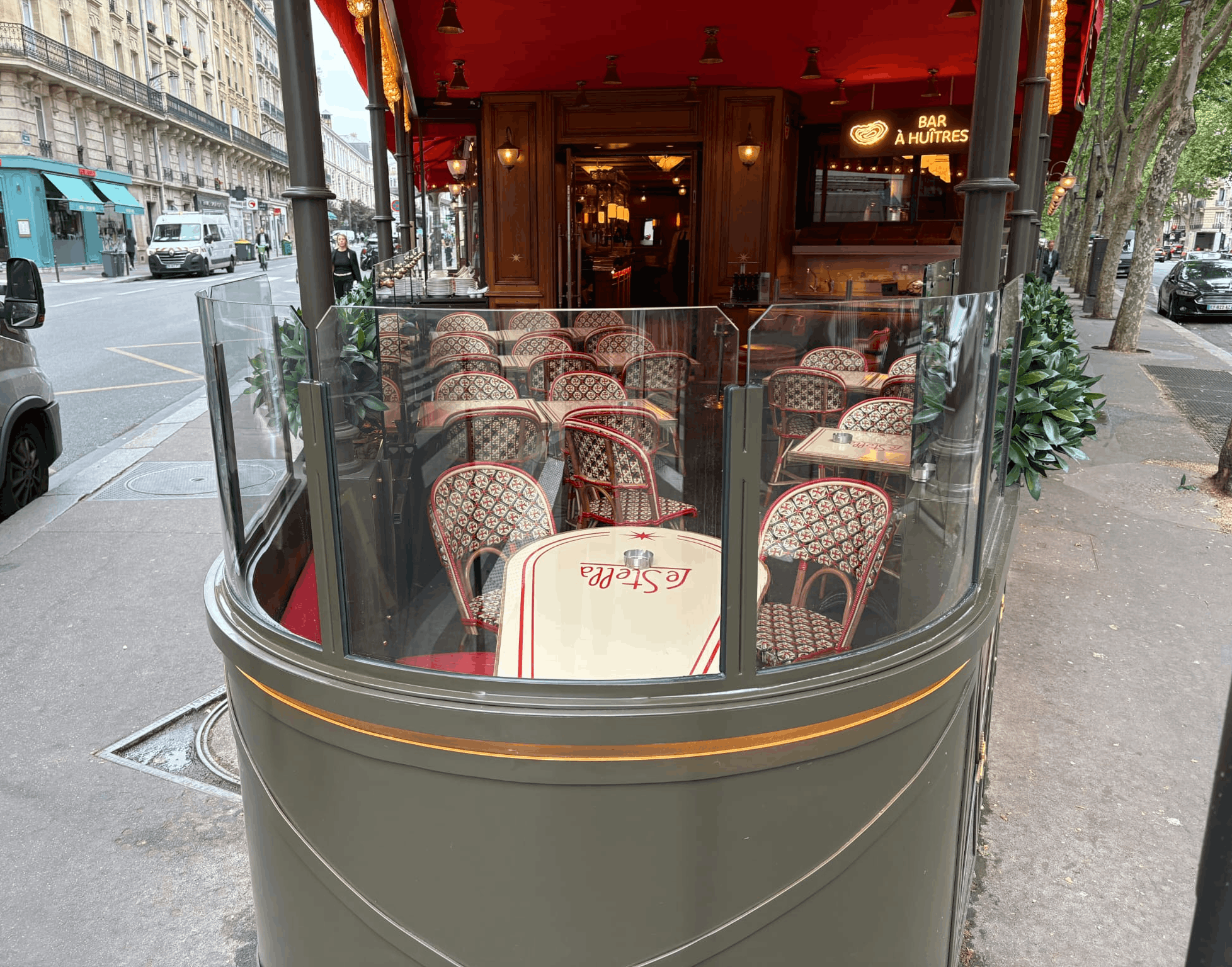Terrasse design avec verre cintré et jardinières Terrasse du restaurant Le Stella avec forme de proue arrondie, verre trempé cintré, jardinières en inox et éclairage décoratif à ampoules filament.